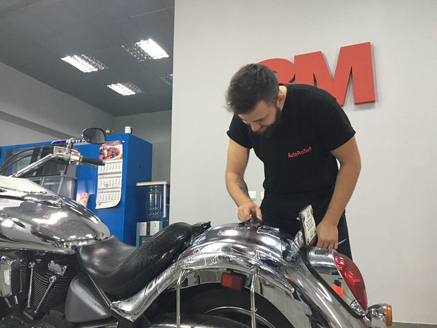 Which parts of the motorcycle should be protected with a film